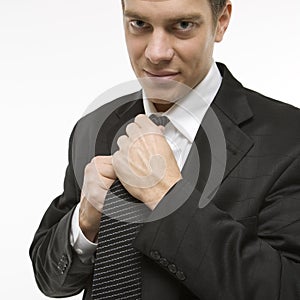 Man straightening necktie.