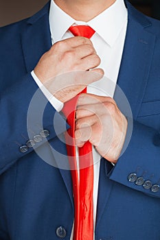 The man straightens his tie