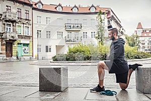 Man streching his legs in the city photo