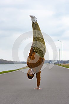 Man street Break Dancer is Dancing in the street. BBOY makes an acrobatic element Freeze