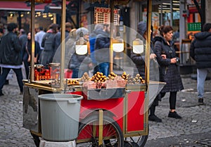 Street vendor selling roasted corns and chestnuts in a crowded street of Istanbul