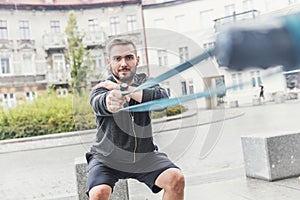 Man strengthening his arms in the city.