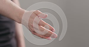 Man stretches hand for a handshake or help on neutral background