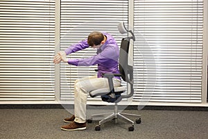 Man stretching arms,exercising on chair