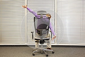 man stretching arms sitting on chair in office