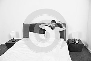 Man stretching in bed. Carefree guy enjoying morning. Wake up. Enjoying carefree morning. Lazy man happy waking up in