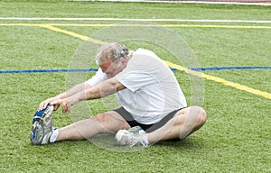 Man stretching exercising field