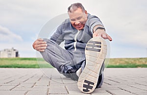 Man, stretching foot and fitness on park ground for training, performance and wellness. Senior male warm up body outdoor