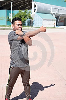 Man stretching his arm and warming up for training