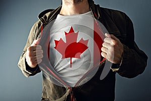 Man stretching jacket to reveal shirt with Canada flag