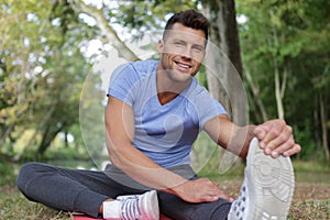 man stretching leg as warm-up before run