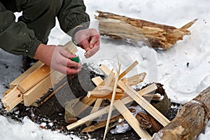 A man strikes a match to make a fire.