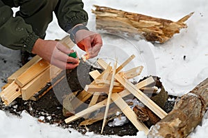 A man strikes a match to make a fire.