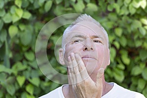A man strokes his chin after shaving