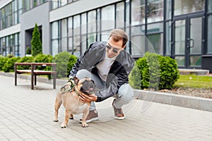 Man stroking french bulldog on street