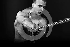 Man with strong muscular arms pulling the chain