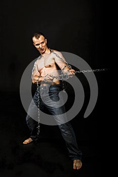 Man with strong muscular arms pulling the chain