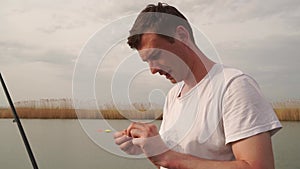 A man strung a worm on the hook of a fishing rod. fisherman.