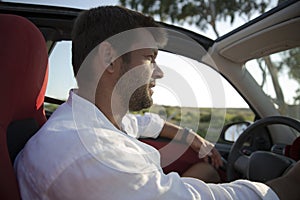 Man with stubble driving rental car