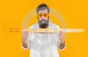 man student hold measuring ruler in studio. man hold measuring ruler on background.