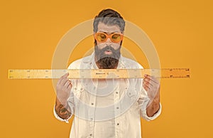 man student hold measuring ruler in studio. man hold measuring ruler on background.