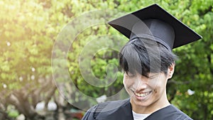 Man student smiles and feel happy in graduation gowns and cap