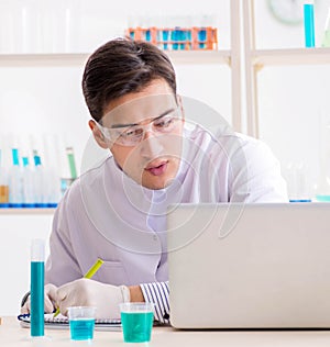 Man student working in chemical lab on experiment