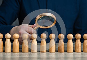 A man studies people through a magnifying glass.