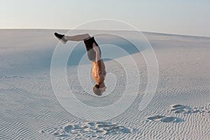 Man study parkour on their own. Acrobatics in the sand