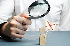 A man is studying a protester through a magnifying glass. Figure of a man with a protest poster. study of protests and action