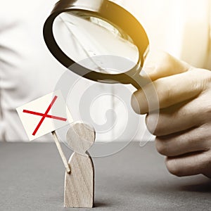 A man is studying a protester through a magnifying glass. Figure of a man with a protest poster. study of protests and action