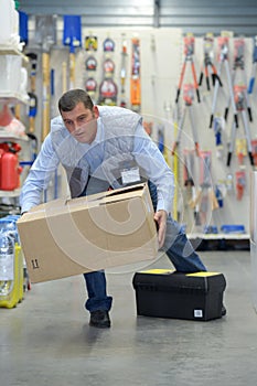 Man stumbling while carrying box photo