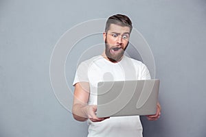 Man with stupid mug using laptop