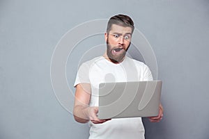 Man with stupid mug using laptop photo