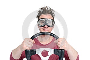 Man in stylish goggles with steering wheel isolated on white background, car driver concept