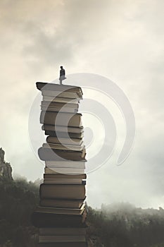 Man successfully reaches the peak of knowledge by  climbing a stack of books