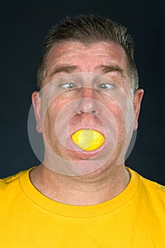 Man sucking on lemon