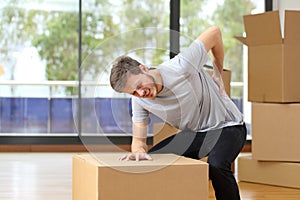 Man suffering back ache moving boxes