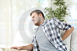 Man suffering back pain at home photo