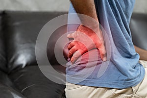 Man suffering from back pain on the sofa at home