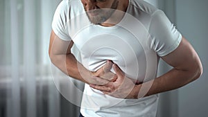 Man suffering bellyache at home, gastritis symptom, peptic ulcer, pancreatitis photo