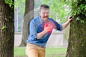 Man suffering from chest pain having heart attack or painful cramps