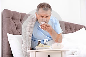 Man suffering from cough and cold in bed