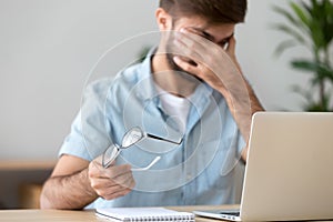 Man suffering from dry eyes syndrome after long computer work photo