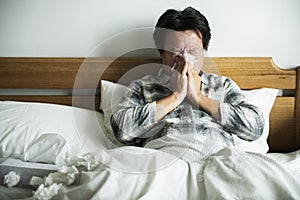 A man suffering from flu sitting in bed