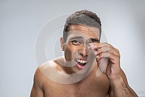 Man suffering during his painful cosmetological procedure