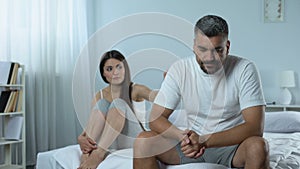 Man suffering problems with masculine health, wife supporting him, impotence