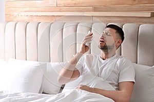 Man suffering from runny nose in bed