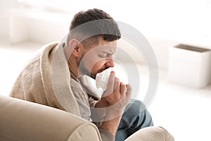 Man suffering from runny nose at home