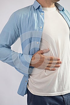 Man suffering from stomach ache on grey background. Health care concept